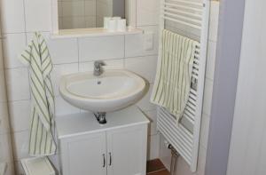 费曼城堡Am Rundsteg 4的白色的浴室设有水槽和镜子