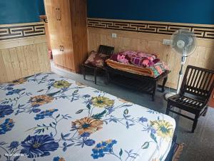 卡尔帕Wanderers Homestay -All mountain facing rooms的一间卧室配有一张床、两把椅子和风扇