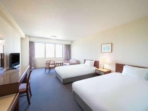 串本町Mercure Wakayama Kushimoto Resort & Spa的酒店客房设有两张床和电视。