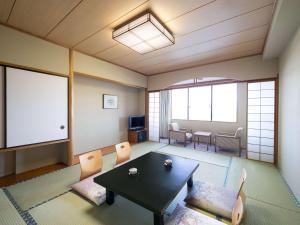 串本町Mercure Wakayama Kushimoto Resort & Spa的配有桌椅和屏幕的房间
