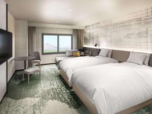 长滨市Grand Mercure Lake Biwa Resort & Spa的酒店客房设有两张床和窗户。