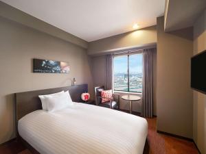 长滨市Grand Mercure Lake Biwa Resort & Spa的酒店客房设有床和窗户。