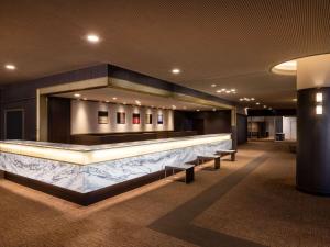 长野Mercure Nagano Matsushiro Resort & Spa的大堂设有酒吧,里面设有长凳
