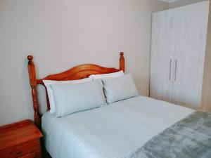 约翰内斯堡Greymont Luxury Apartments w Backup Inverter, Unlimited 100Mpbs WiFi的卧室内的一张带白色床单和枕头的床