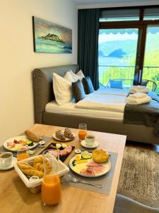 兰斯科伦Apartment am Ossiacher See mit See Blick的一间房间,配有一张床和一张桌子,上面有食物