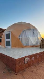 瓦迪拉姆wadi rum fox road camp & jeep tour的沙漠中一座建筑物顶上的帐篷