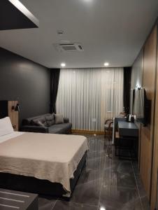 PelitliBurç Otel的一间卧室配有一张床、一张沙发和一张书桌
