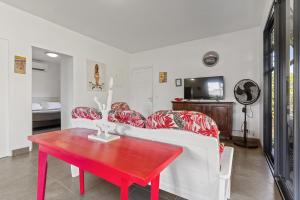 TemaeMagie de Moorea Serenite的客厅配有红色桌子和白色沙发
