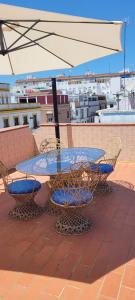 塞维利亚Casa El limonero的屋顶上配有遮阳伞的桌椅