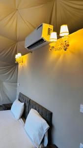 瓦迪拉姆wadi rum fox road camp & jeep tour的卧室配有一张床铺,墙上配有投影仪
