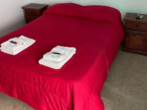 特尔马斯德里奥翁多Hotel Sol的一张带红色床单和毛巾的床