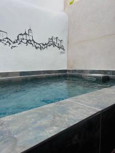 贝尔蒙特Casa Rural La Simona的墙上画画的游泳池