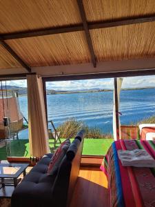 普诺Uros Aruma-Uro on Uros Floating Islands的带沙发的客厅,享有海景