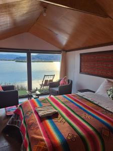 普诺Uros Aruma-Uro on Uros Floating Islands的一间卧室配有一张床,享有水景