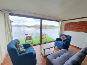 普诺Uros Aruma-Uro on Uros Floating Islands的客厅设有2把蓝色椅子和大窗户