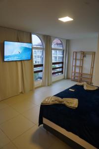 里约热内卢Surf'O Hostel的一间卧室配有一张床和一台平面电视
