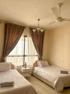马斯喀特SIRA apartment 1的一间卧室设有两张床和窗户。