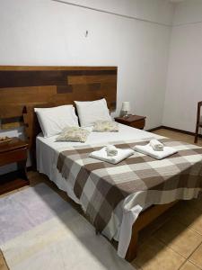 贝贝里比Pousada Villa Flamboyant的一间卧室配有一张大床和两条毛巾