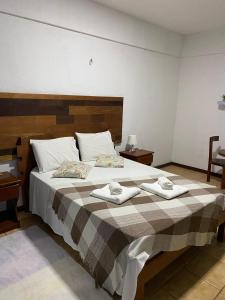 贝贝里比Pousada Villa Flamboyant的一间卧室配有一张大床和两条毛巾
