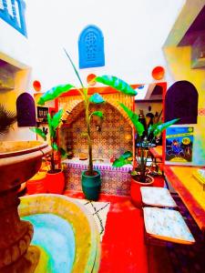 马拉喀什riad cherif的红色地板上的一个有盆栽的房间,有一个喷泉