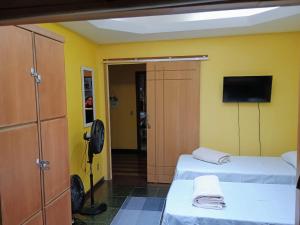 彼得罗波利斯Village Hostel的客房设有两张床和一台平面电视。