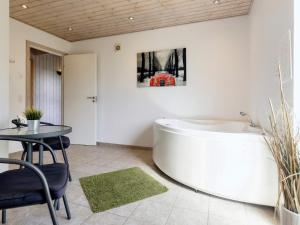 Egense10 person holiday home in Storvorde的配有桌子、桌子和桌子的客房内的浴缸