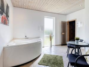 Egense10 person holiday home in Storvorde的一个带桌子的房间的白色大浴缸