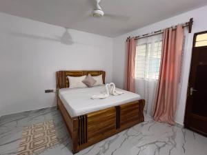 南威Nungwi Beach Front Ex Sunrise Beach Nungwi的一间卧室配有一张带白色床单的床和一扇窗户。