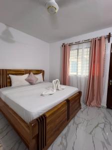 南威Nungwi Beach Front Ex Sunrise Beach Nungwi的一间卧室配有一张带白色床单的床和一扇窗户。