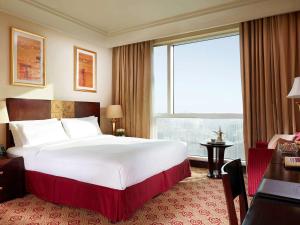 麦加普尔曼赞姆赞姆麦加酒店的一张位于酒店客房的大床,设有大窗户