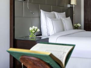 麦加麦加瑞士酒店的一张带书和花瓶的桌子上床