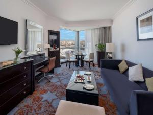 麦加麦加瑞士酒店的客厅配有蓝色的沙发和书桌