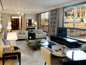 麦地那麦地那普尔曼扎姆扎姆酒店的客厅配有家具和大窗户。