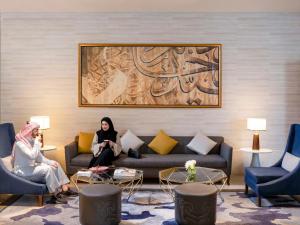 麦加麦加哈加塔瑞享酒店的两个女人坐在客厅的沙发上