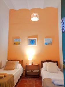 科洛尼亚-德尔萨克拉门托Casa Calma的一间设有两张床和一盏灯的房间