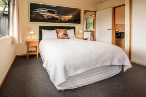 格雷默斯Goldfield Suites的卧室设有一张白色大床和一扇窗户。