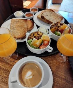 圣马丁德洛斯Hotel & Spa La Cheminée的桌上的食品托盘,包括三明治和果汁