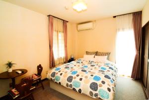 南鱼沼市美景西浦山林小屋的一间卧室配有一张床、一张桌子和一个窗户。