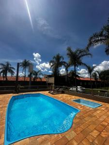 MatãoHOTEL POUSADA SÃO PEDRO MATÃO的一座种植了棕榈树的蓝色游泳池
