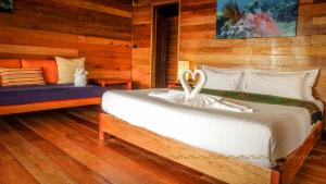 丽贝岛腾姆恩斯利普度假村的一间卧室设有一张带木墙的大床
