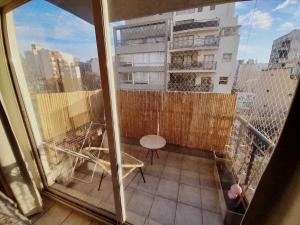 布宜诺斯艾利斯Turismo Aparts Urquiza的大楼内的阳台配有桌椅