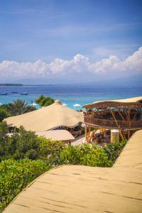 吉利特拉旺安特拉旺甘明珠酒店的享有海滩美景,配有遮阳伞和海洋美景。