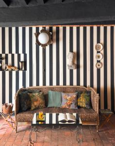 贝莱姆AU LIT ON DORT - Logis de Village的一张沙发,位于带条纹墙的房间