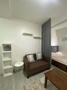 马尼拉Cozy & Minimalist Room at Amaia Steps Alabang的客厅配有沙发和1张床