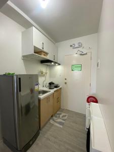 马尼拉Cozy & Minimalist Room at Amaia Steps Alabang的厨房配有不锈钢冰箱和水槽