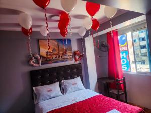 利马hostal paris的卧室配有红色和白色气球,位于床上方