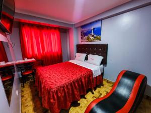 利马hostal paris的一间卧室配有一张带红色窗帘的床和一把椅子