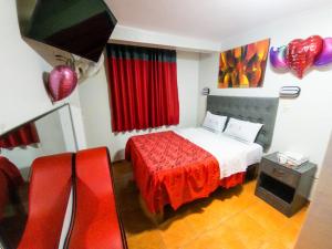 利马hostal paris的一间卧室配有一张红色床罩的床