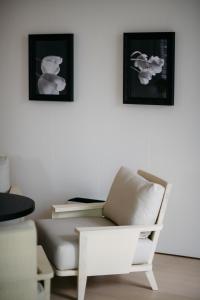 新加坡The Singapore EDITION的客厅配有沙发和墙上的两张照片