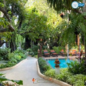 清迈扬塔拉斯瑞度假酒店的花园内的游泳池,花园内设有喷泉